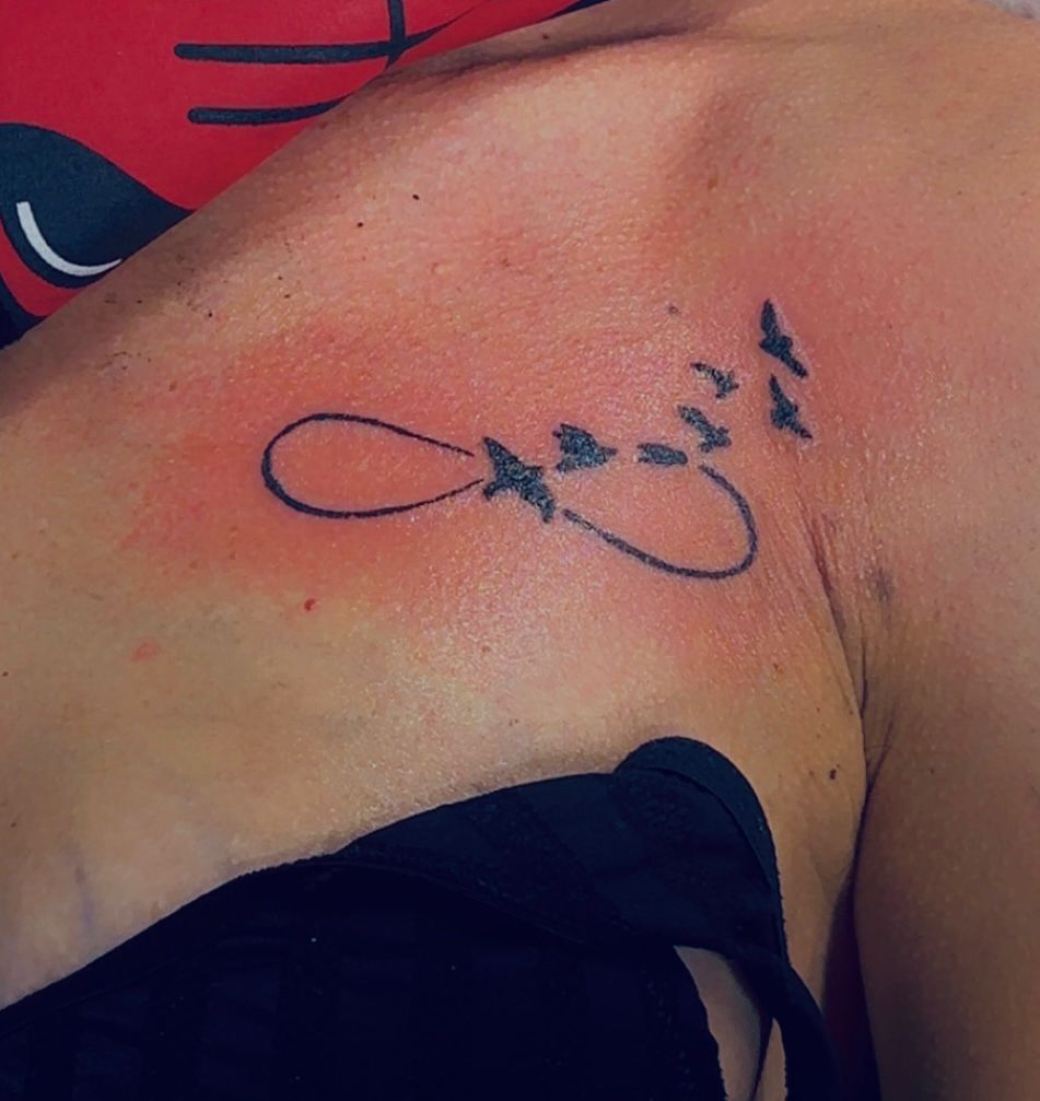 Tatouage fineline symbole infini avec oiseaux sur clavicule Hakuna Tattoo Arpajon 91
