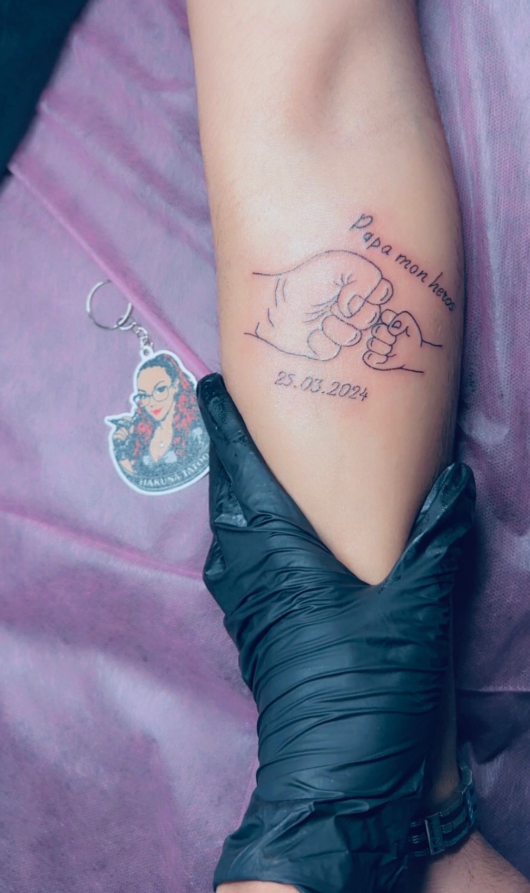 Tatouage rouge et noir poing de bebe papa mon heros avec date sur avant-bras Hakuna Tattoo
